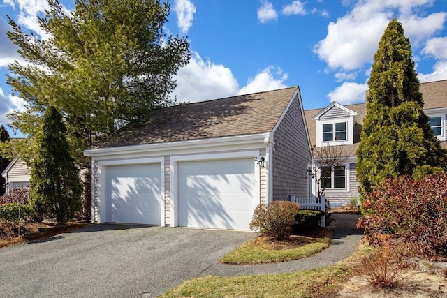 view of front of home featuring a garage and roof with shingles