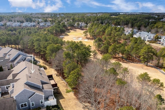 drone / aerial view featuring a wooded view and a residential view