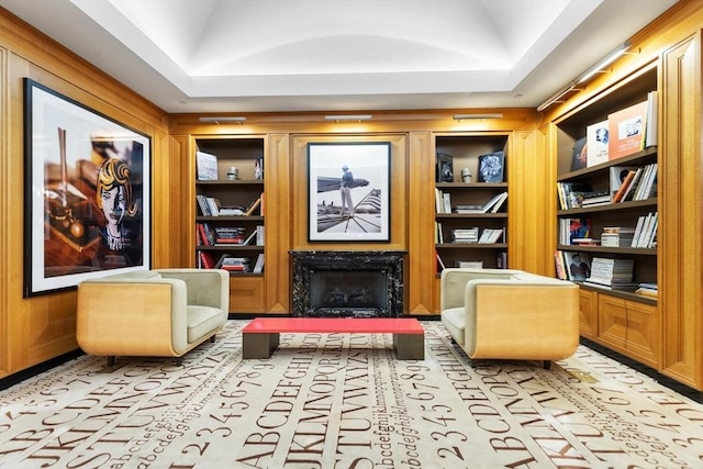 living area featuring vaulted ceiling, built in features, and a high end fireplace