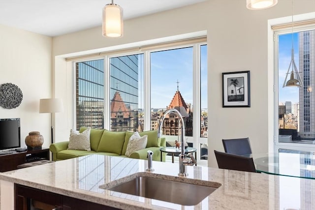 kitchen featuring a view of city, hanging light fixtures, plenty of natural light, and a sink