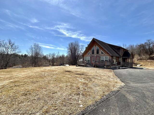 view of home's exterior featuring a deck and aphalt driveway