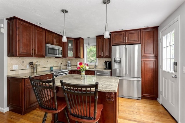 194 Crossfield Rd, Franklin, MA 02038 - kitchen featuring appliances with stainless steel finishes, light wood-type flooring, backsplash, and pendant lighting