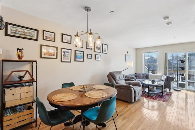 dining space featuring light hardwood / wood-style floors and a notable chandelier