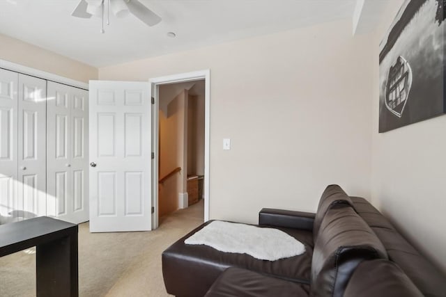 living area with ceiling fan and light colored carpet