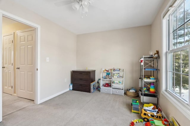 rec room with ceiling fan and light carpet