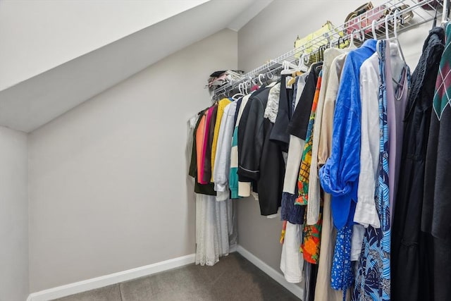 walk in closet featuring dark carpet and lofted ceiling