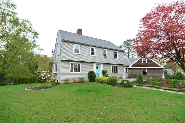 back of property featuring a chimney, a lawn, and a patio area