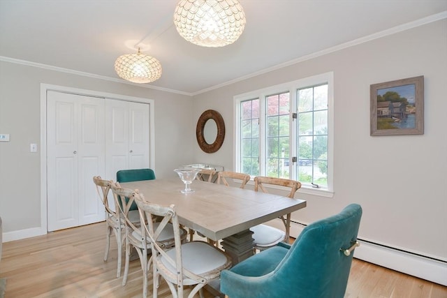 dining space with a baseboard heating unit, crown molding, light wood-type flooring, baseboards, and a chandelier