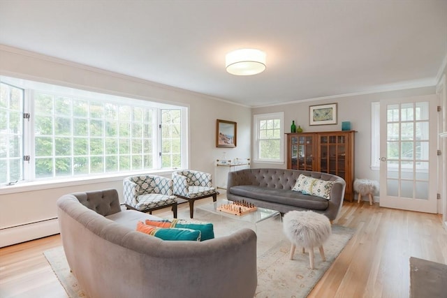 living area with crown molding, wood finished floors, and a baseboard heating unit