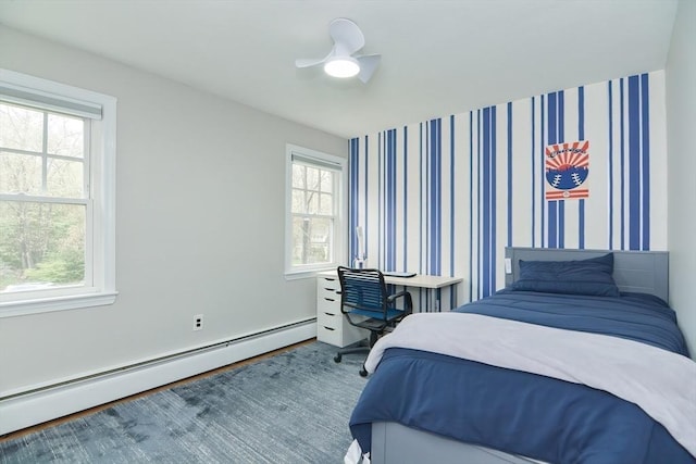 bedroom with a baseboard radiator, wood finished floors, and a ceiling fan
