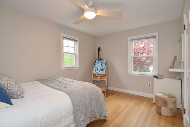 bedroom featuring light wood-style floors, baseboards, and ceiling fan