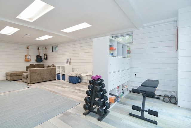 workout room featuring wooden walls and wood finished floors