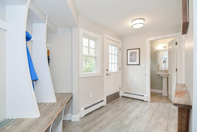mudroom with a baseboard heating unit, light wood-type flooring, and baseboards