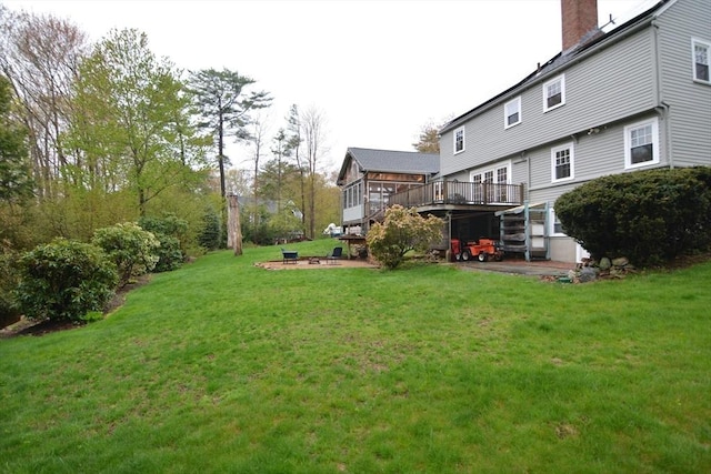 view of grassy yard featuring a wooden deck and stairs