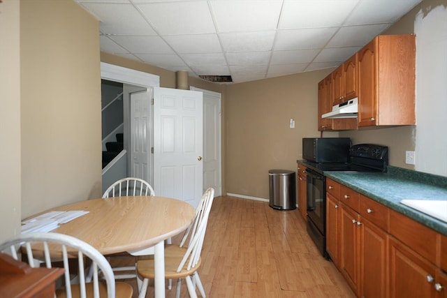 kitchen featuring black appliances, a paneled ceiling, and light hardwood / wood-style floors