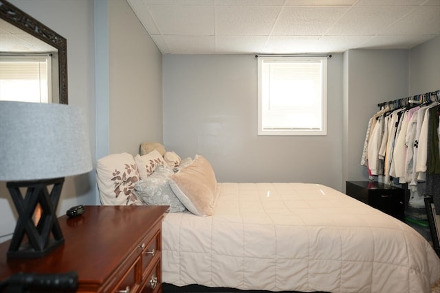 bedroom with multiple windows and a paneled ceiling