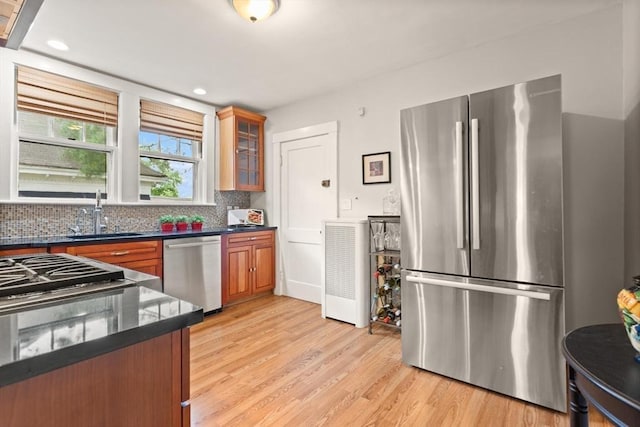 17-19 Newtonville Ave Unit 2, Newton, MA 02458 - kitchen featuring appliances with stainless steel finishes, a sink, brown cabinets, light wood-style floors, and tasteful backsplash