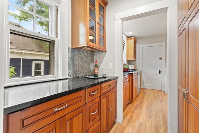 17-19 Newtonville Ave Unit 2, Newton, MA 02458 - kitchen featuring light wood finished floors, glass insert cabinets, backsplash, brown cabinetry, and dark stone countertops