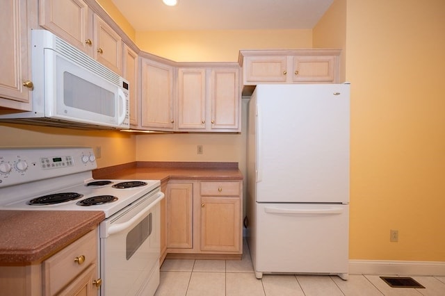 kitchen with white appliances, light brown cabinets, and light tile patterned floors