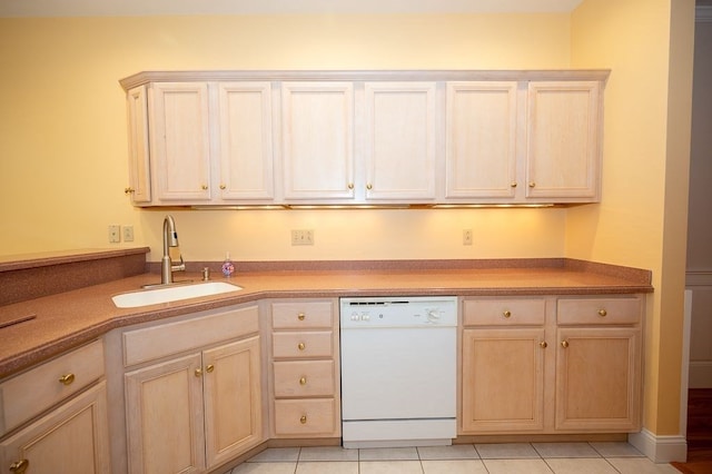 kitchen with dishwasher, light brown cabinetry, light tile patterned floors, and sink