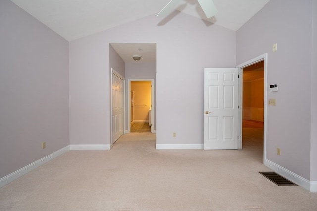 unfurnished bedroom featuring lofted ceiling, ceiling fan, and light colored carpet