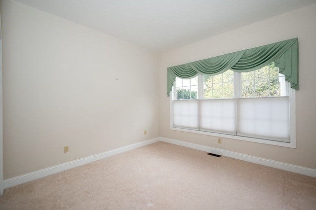 carpeted spare room featuring a wealth of natural light