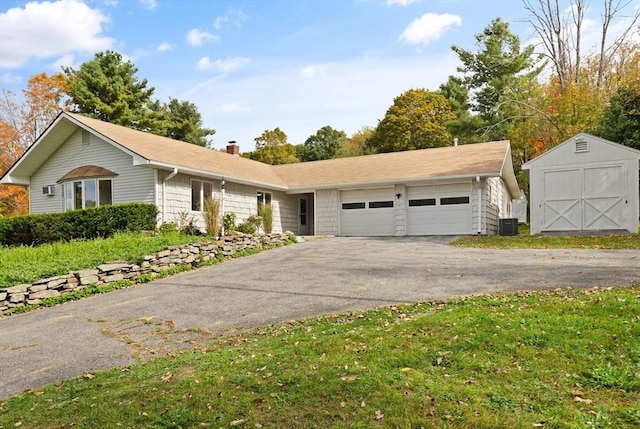 ranch-style home featuring central air condition unit and a storage unit