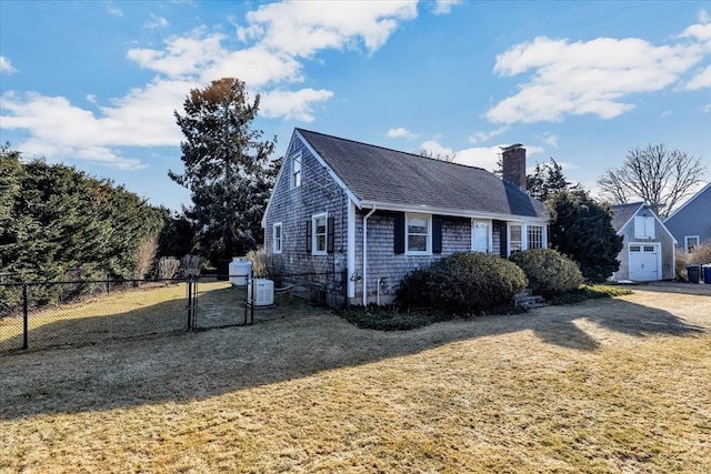 view of front facade featuring a front yard, a chimney, fence, and a shingled roof