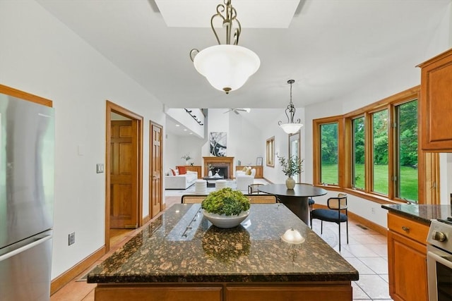 9 Buffalo Run, Southborough, MA 01772 - kitchen featuring stainless steel appliances, a fireplace, light tile patterned floors, dark stone counters, and pendant lighting
