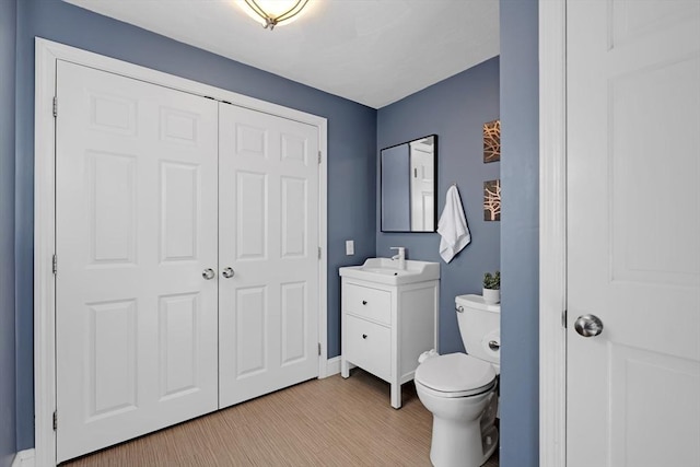 bathroom featuring vanity, toilet, and wood finished floors