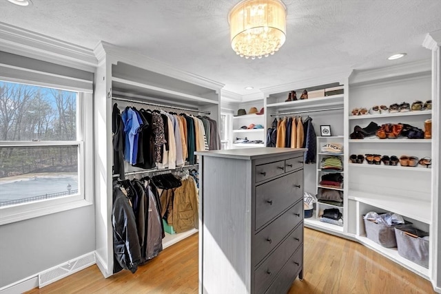 walk in closet featuring a chandelier, visible vents, and light wood-type flooring