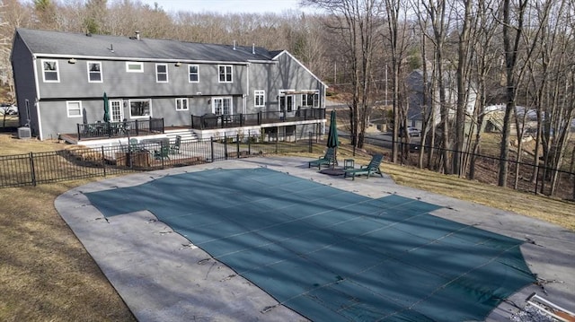 back of house with a patio, cooling unit, a fenced in pool, fence, and a deck