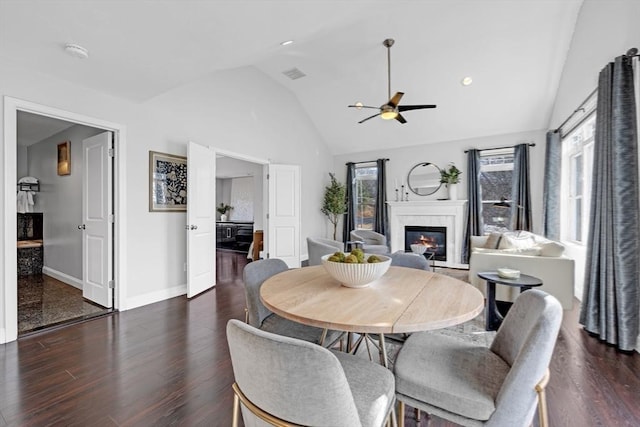 dining space with a ceiling fan, baseboards, wood finished floors, visible vents, and a premium fireplace