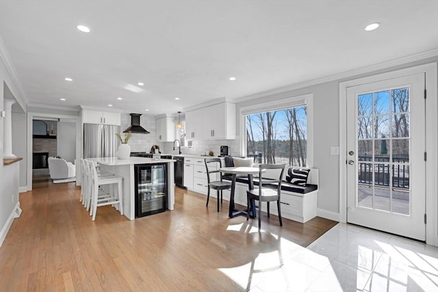 kitchen with freestanding refrigerator, wine cooler, wall chimney exhaust hood, crown molding, and dishwasher