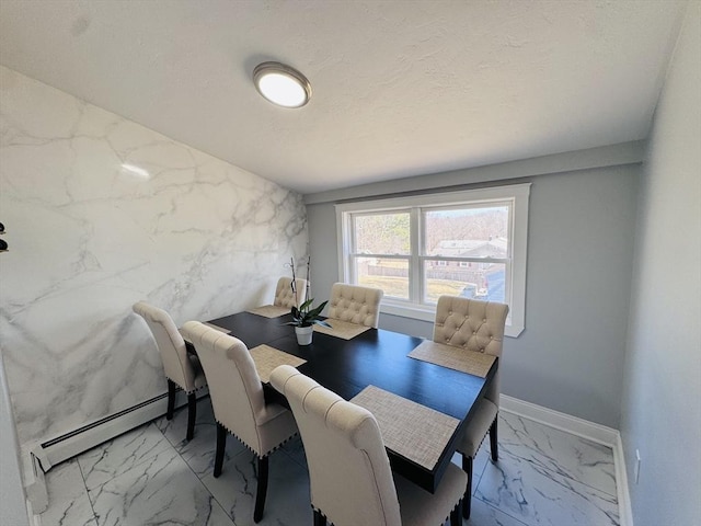 dining room featuring a baseboard heating unit, baseboards, a textured ceiling, and marble finish floor