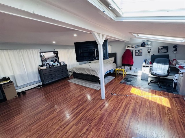 bedroom with lofted ceiling and wood finished floors