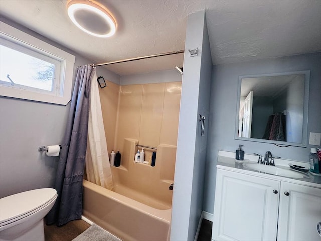 full bath featuring toilet, shower / bath combo, vanity, and a textured ceiling