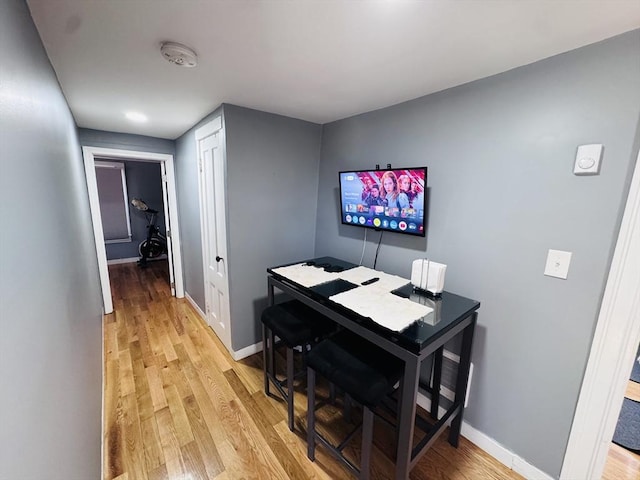 dining space featuring baseboards and light wood finished floors