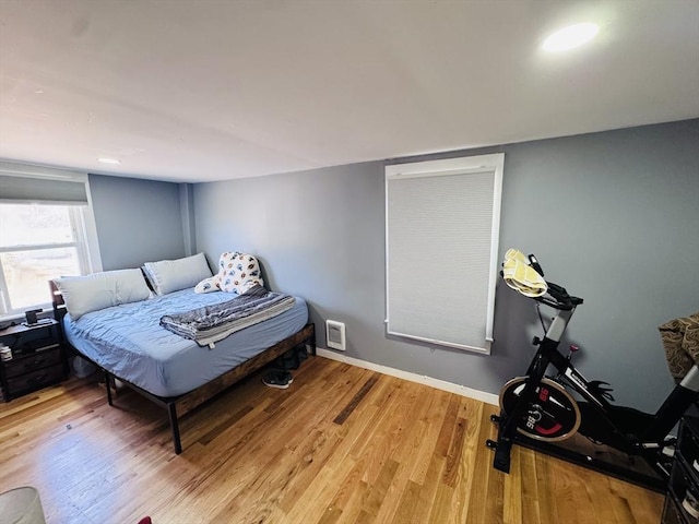 bedroom with light wood finished floors and baseboards