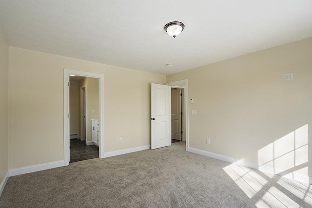 unfurnished bedroom with carpet, baseboards, and ensuite bath