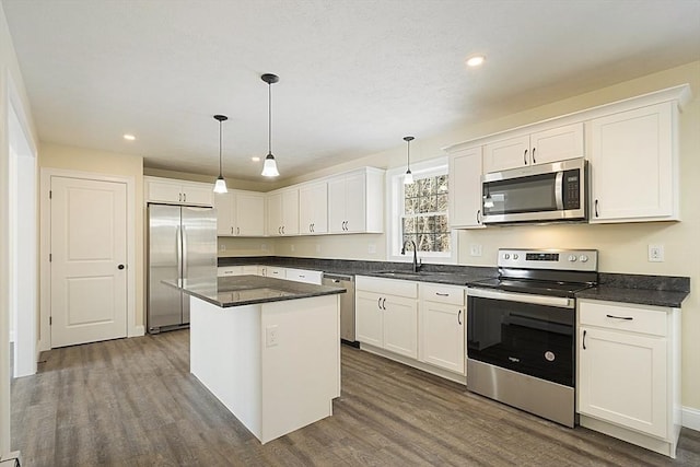 kitchen with stainless steel appliances, dark wood-type flooring, white cabinetry, dark countertops, and recessed lighting