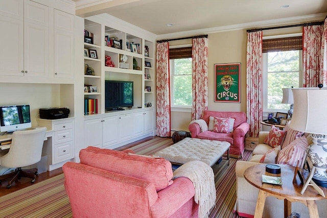 living room with wood-type flooring, built in features, and crown molding