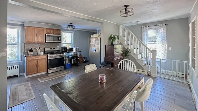 dining area featuring a textured ceiling, dark wood-type flooring, and radiator heating unit