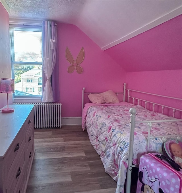 bedroom featuring radiator heating unit, a textured ceiling, wood-type flooring, and vaulted ceiling