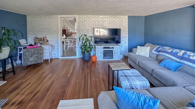 living room with a textured ceiling and hardwood / wood-style flooring