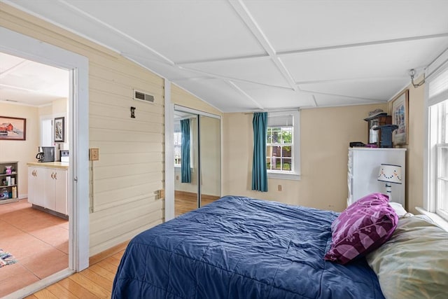 64 Bayside Dr, Falmouth, MA 02540 - bedroom featuring light wood finished floors, a closet, and wooden walls