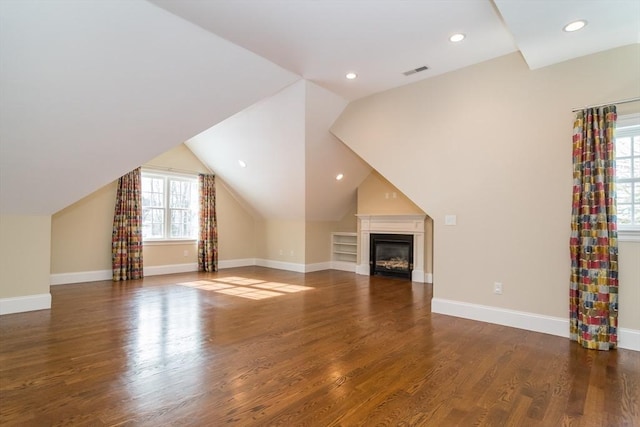 unfurnished living room featuring dark wood-type flooring and lofted ceiling