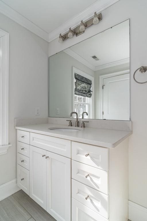 bathroom featuring vanity, crown molding, and wood-type flooring