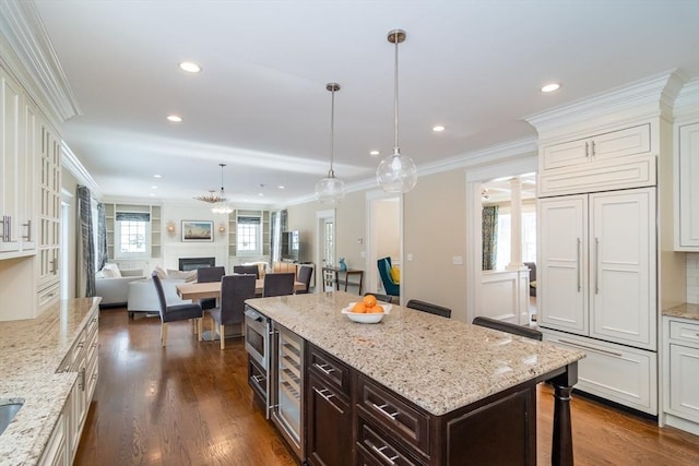 kitchen featuring dark brown cabinets, ornamental molding, and dark hardwood / wood-style floors