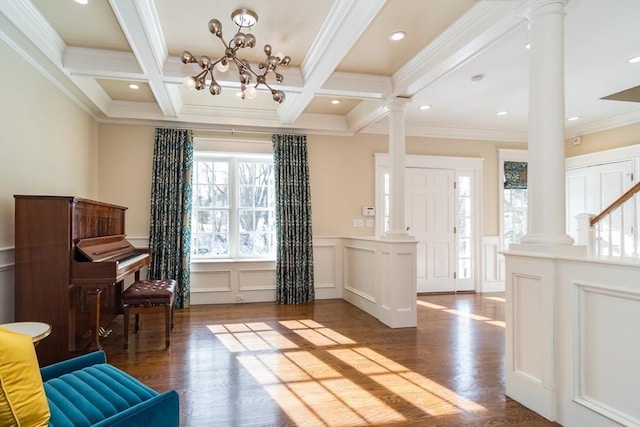 sitting room featuring beamed ceiling, wood-type flooring, and ornate columns